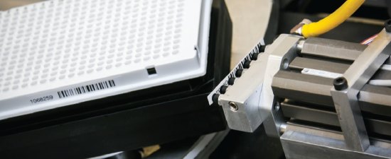 A robotic barcode applicator labelling a deep well plate