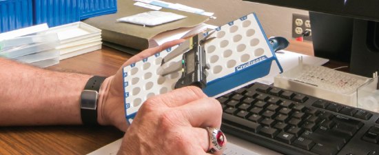 An SSI team member handling a molded plate component at a design workstation